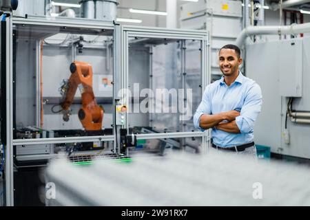 Smiling businessman standing in a factory Stock Photo