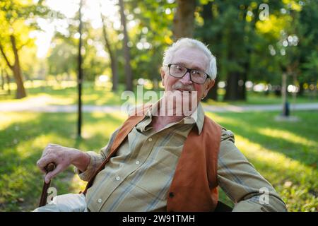Smiling senior man sitting in park Stock Photo