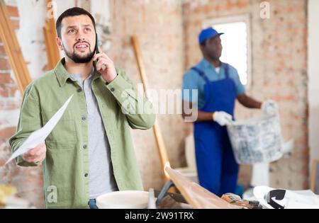 Man architect having telephone conversation about project documentation Stock Photo