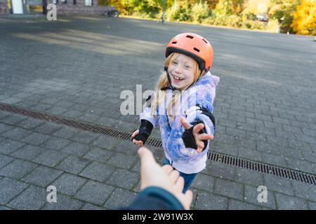 Happy girl wearing helmet giving high-five to mother Stock Photo