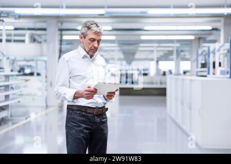 Mature engineer using tablet PC in factory Stock Photo