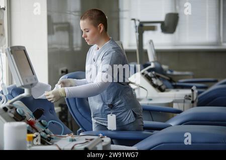 Healthcare worker preparing couch at blood donation center Stock Photo