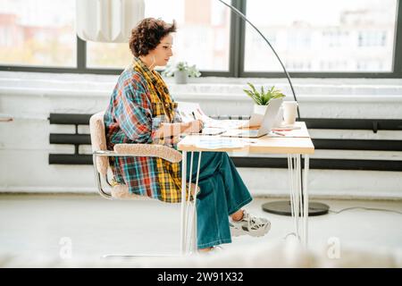 Young graphic designer working and sitting on chair at office Stock Photo