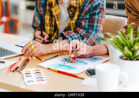 Illustrators making design on paper at desk in office Stock Photo