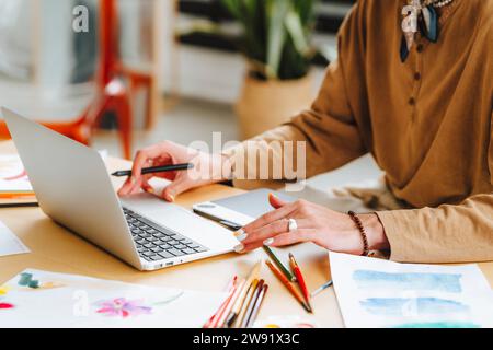 Young male illustrator using laptop in creative office Stock Photo - Alamy