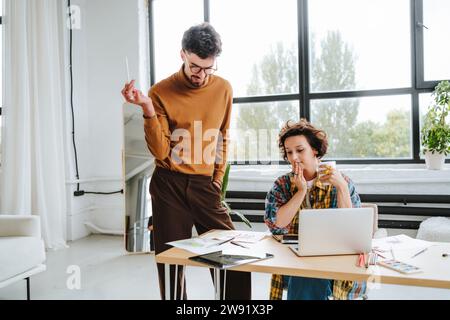 Young design illustrators working together at desk in office Stock Photo