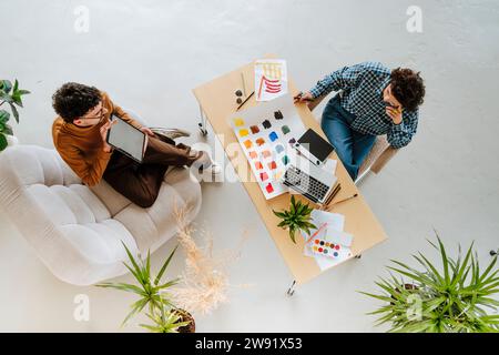 Graphic designers planning together sitting at desk in office Stock Photo