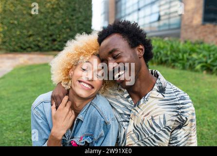 Smiling boyfriend embracing transgender woman at park Stock Photo