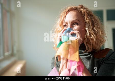 Businesswoman covering mouth with bunting Stock Photo