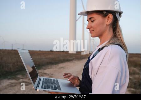 Smiling engineer working on laptop at field Stock Photo