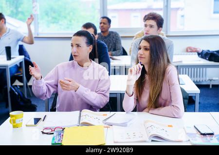 Student gesturing and discussing in lecture at classroom Stock Photo