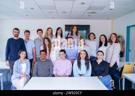 Smiling multi-ethnic students together in classroom Stock Photo