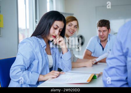 Student reading book and studying at desk in classroom Stock Photo