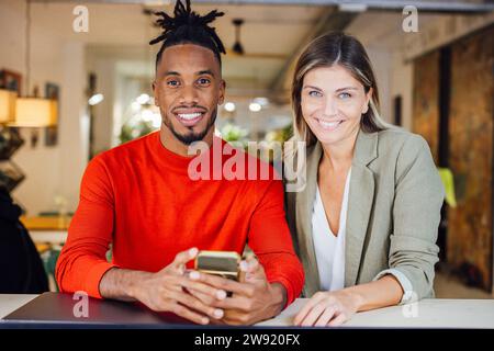 Smiling multiracial architects sitting at cafe Stock Photo