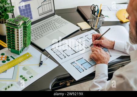 Architect working on blueprint at desk Stock Photo