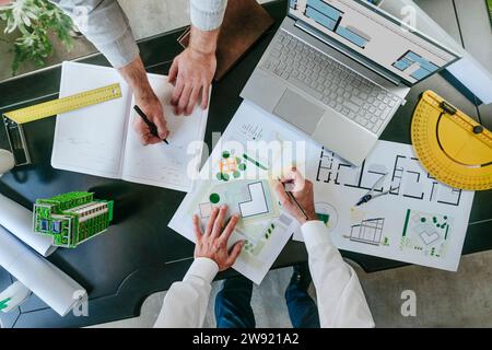 Architects working on blueprints at desk Stock Photo