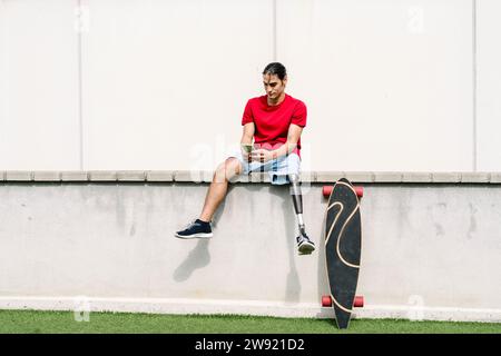 Young man with disability using smart phone Stock Photo