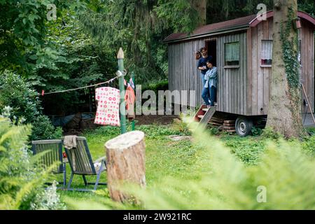 Man and woman standing in log cabin doorway Stock Photo