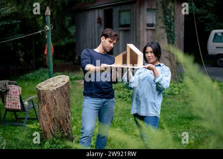 Architects examining model house in front of log cabin Stock Photo