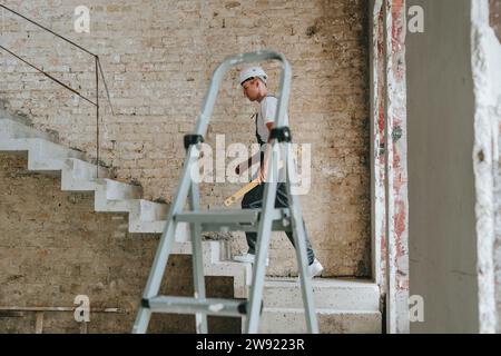 Civil engineer moving up on staircase at site Stock Photo