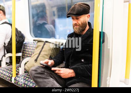 Man using smart phone sitting in train Stock Photo