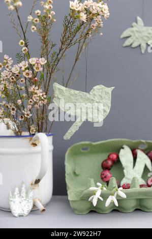 Studio shot of DIY Easter decorations and blooming flowers in enamel jug Stock Photo