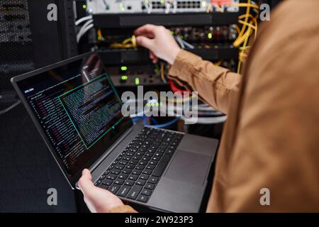 Administrator with laptop working in server room Stock Photo
