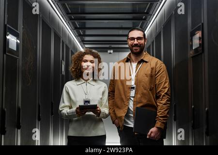 Smiling IT engineers standing in server room Stock Photo