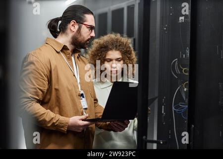 Young engineers checking servers with laptop in data center Stock Photo