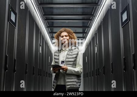Smiling engineer with tablet PC standing in server room Stock Photo