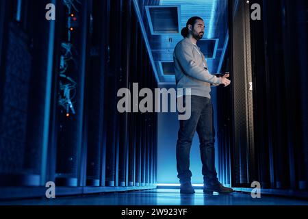 Young IT engineer examining supercomputer equipment in server room Stock Photo