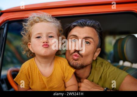 Father and daughter puckering inside motor home Stock Photo