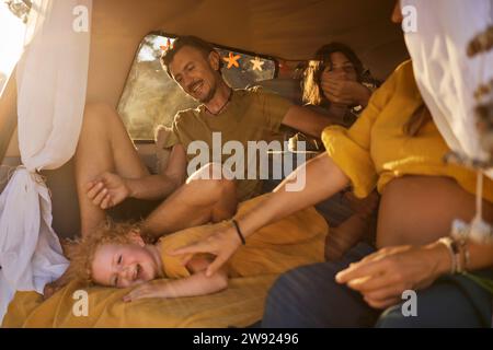 Smiling family spending leisure time together in motor home on vacation Stock Photo