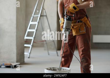 Construction worker mixing cement at site Stock Photo