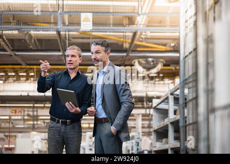 Businessmen having discussion over tablet PC in warehouse Stock Photo