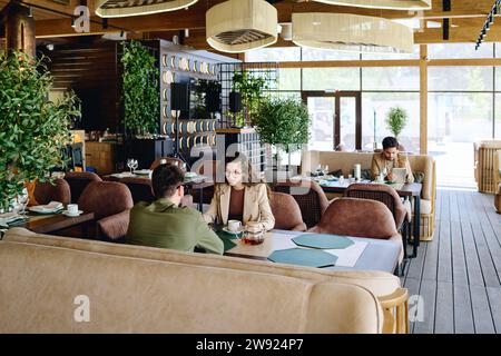 Businesswoman discussing with colleague and having lunch at restaurant Stock Photo