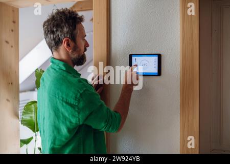 Man controlling temperature on tablet PC at home Stock Photo