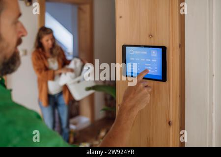 Man adjusting temperature through app on tablet PC at home Stock Photo