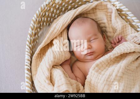 Newborn baby boy sleeping in moses basket Stock Photo