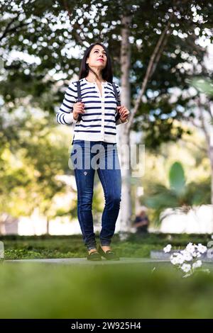 Thoughtful woman standing in park Stock Photo