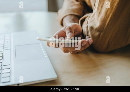 Young man text messaging through mobile phone on table at home Stock Photo