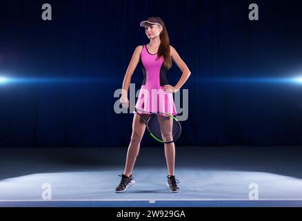 Portrait of a beautiful tennis player in a pink dress on the court. Sports concept. Mixed media Stock Photo