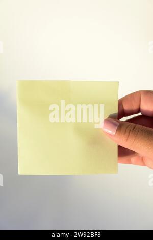 Woman's hand with painted nails holding blank letter paper on pure white background Stock Photo
