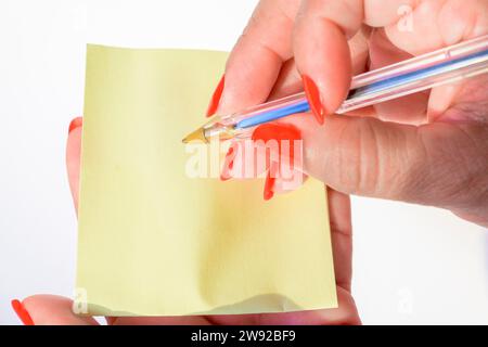 Woman's hand with painted nails holding blank letter paper on pure white background Stock Photo