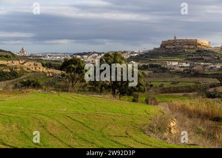 The imposing church dome in Xewkija, dedicated to St. John the Baptist, and the citadel of Rabat (Victoria) are striking landmarks on the horizon of the island of Gozo. Viewed from Għasri, Gozo, Malta Stock Photo