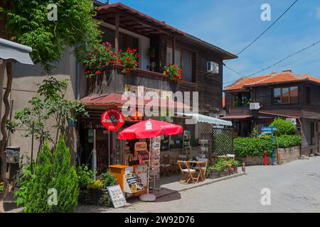 Souvenir shop with cosy seating and red parasol in front of a traditional house with flowers, typical Black Sea architecture, Old Town, Sosopol Stock Photo