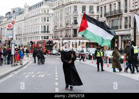 London, UK. 23 December 2023. March organised by Sisters Uncut in support of Palestine. Hundreds march through Oxford Street and Carnaby Street to call for a ceasefire in Gaza and a boycott of high street brands with links to Israel. Credit: Andrea Domeniconi/Alamy Live News Stock Photo