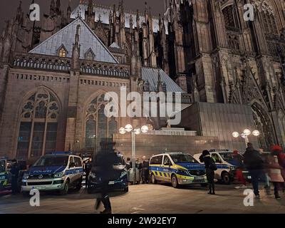 Cologne, Germany. 23rd Dec, 2023. Police emergency vehicles in front of the cathedral. Visitors to religious services at Cologne Cathedral and tourists must be prepared for increased security standards over the next few days. The police will take special protective measures due to a threat report, the authorities announced on 23.12.2023. State security, which is active in politically motivated crimes, has started investigations. (to dpa 'Cologne Cathedral with special protective measures: sniffer dogs on duty') Credit: Sascha Thelen/dpa/Alamy Live News Stock Photo
