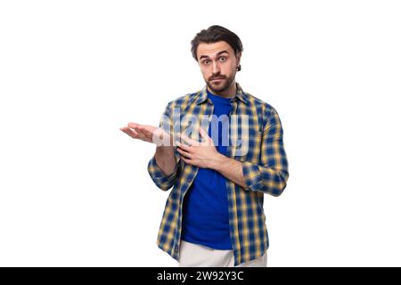 young caucasian brunette man with a beard and an earring is dressed in a blue plaid shirt and t-shirt refuses the offer Stock Photo