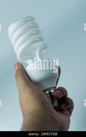 Spiral shaped bulb held in hand isolated on white background Stock Photo
